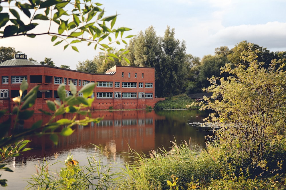 a red building sitting on the side of a river