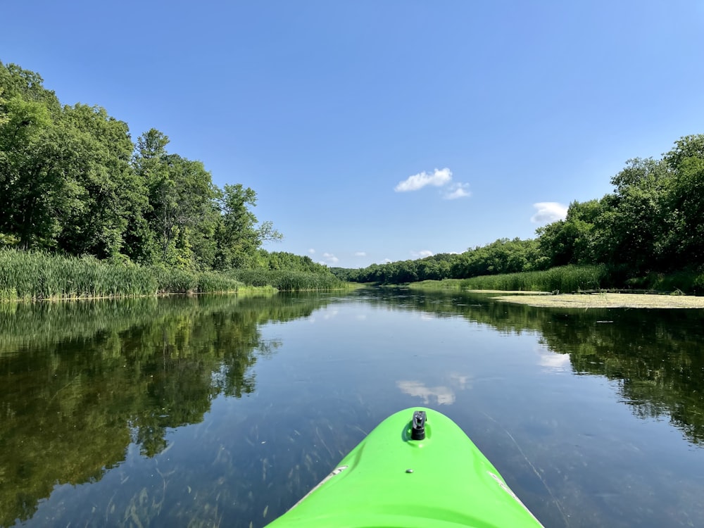 a green kayak in the middle of a river