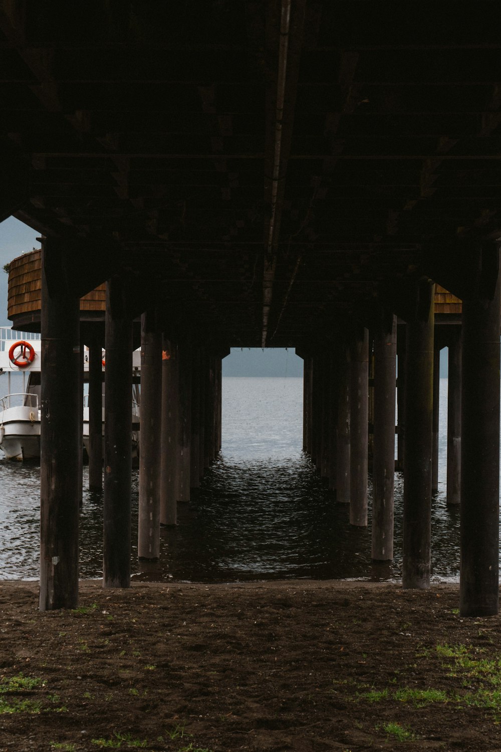 a boat is under a pier on the water