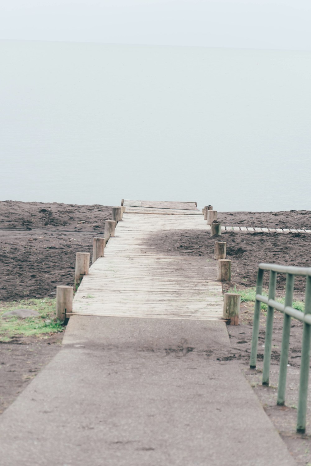 a wooden walkway leading to a body of water