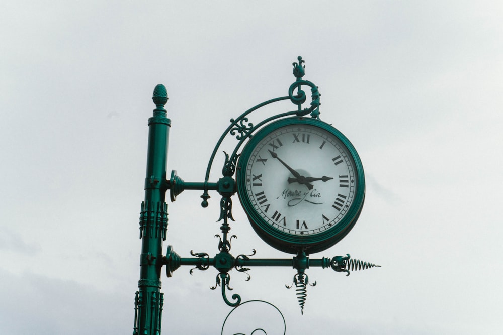 a clock on a pole with a sky background
