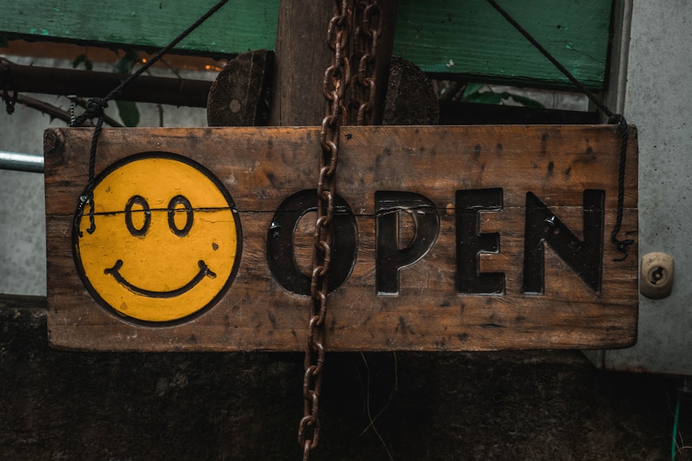 une enseigne en bois avec un visage souriant peint dessus