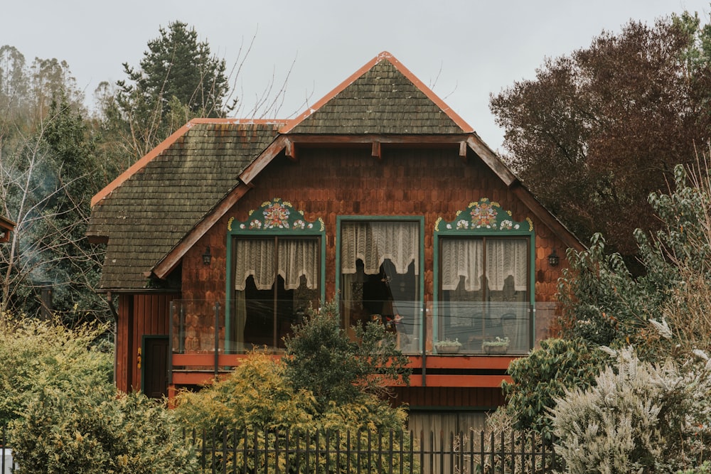 ein Holzhaus mit grünen Zierleisten und Fenstern