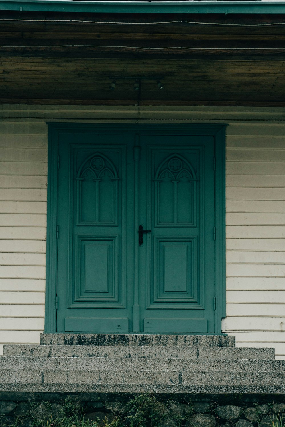 a cat sitting on the steps of a house