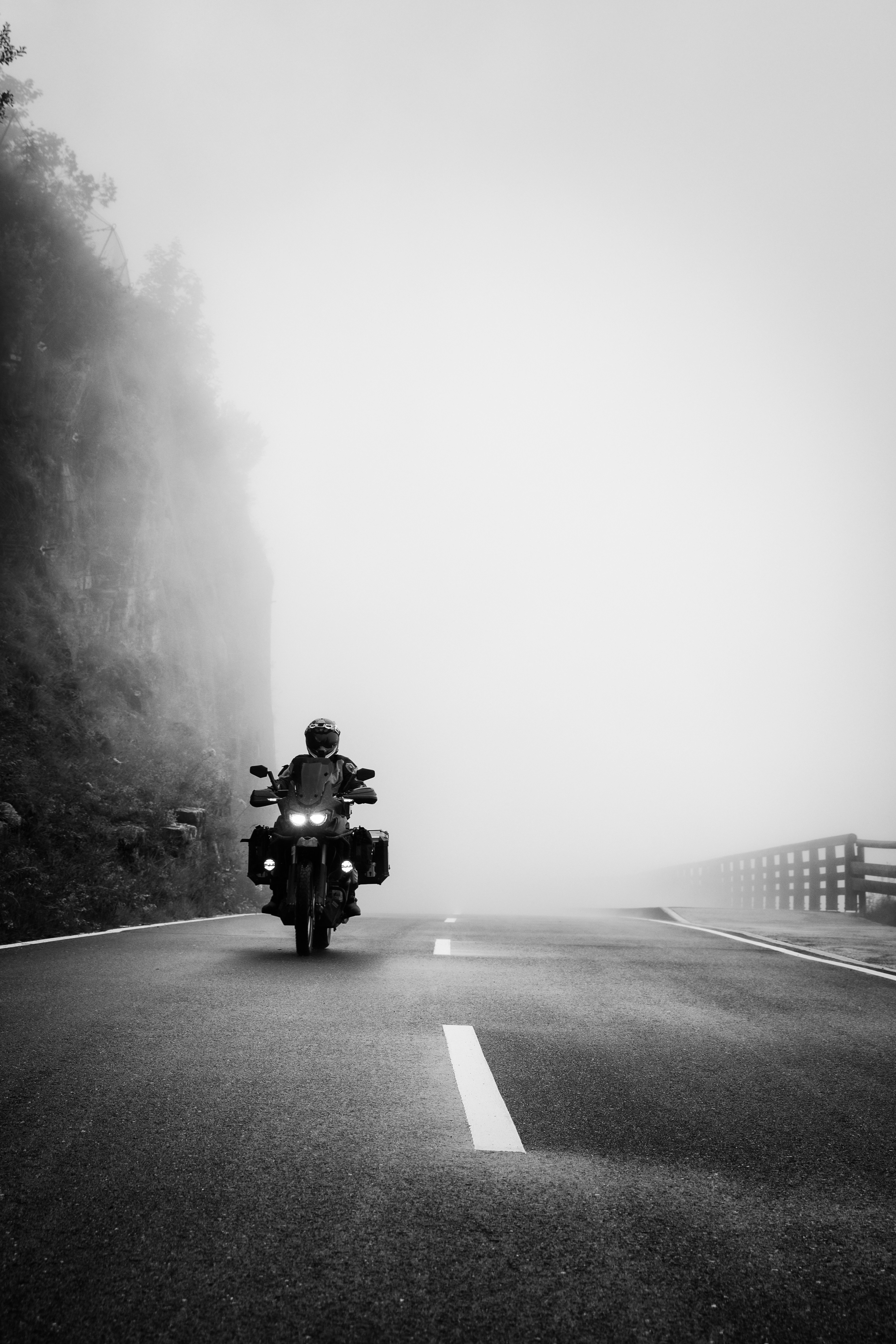 a person riding a motorcycle on a foggy road