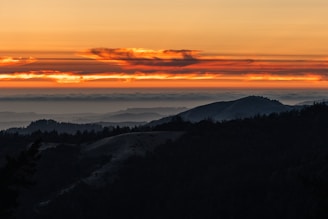A vibrant landscape showcasing a breathtaking sunset over rolling hills.
