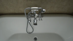 Modern bathroom fittings including faucets and showerheads displayed on a showroom wall
