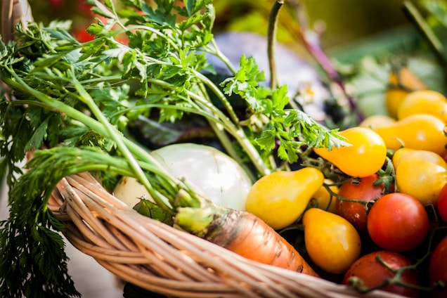 A vibrant basket overflowing with freshly picked fruits and vegetables, glowing under natural sunlight.