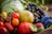 A variety of fresh fruits and vegetables including tomatoes, a pear, grapes, and plums are arranged in a basket. The scene is colorful and vibrant, with the focus on the natural textures and colors of the produce.