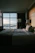 A warmly lit hotel room with cozy bedding and soft evening light streaming through the window.