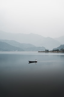 a lone boat floating on top of a large body of water