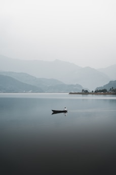 a lone boat floating on top of a large body of water