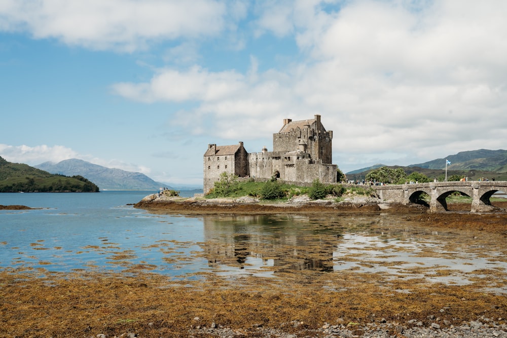 a castle sitting on top of a small island next to a body of water