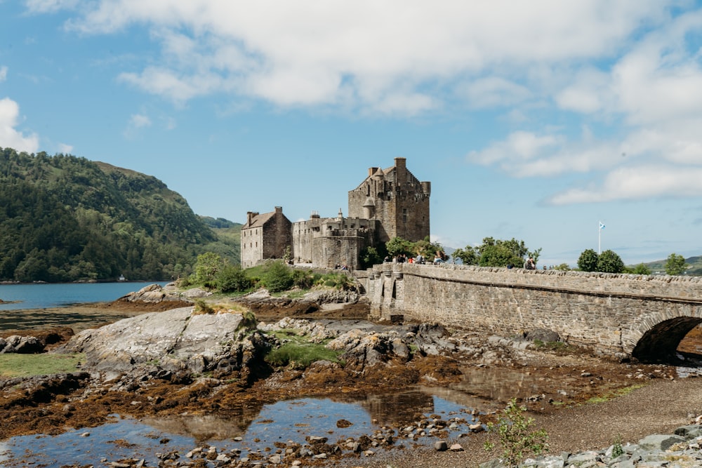 un pont de pierre traversant une rivière devant un château