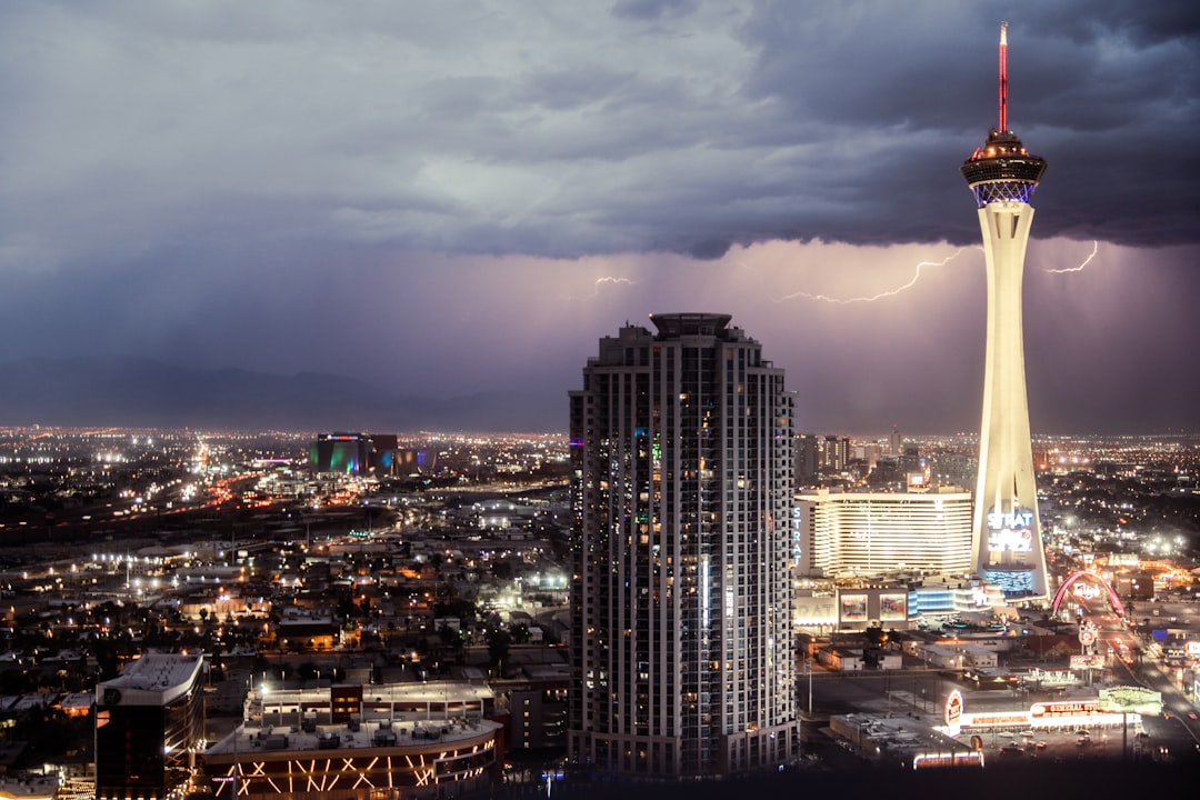 a lightning bolt strikes over a city at night, View from my hotel room as a thunderstorm hits the edge of the Las Vegas 