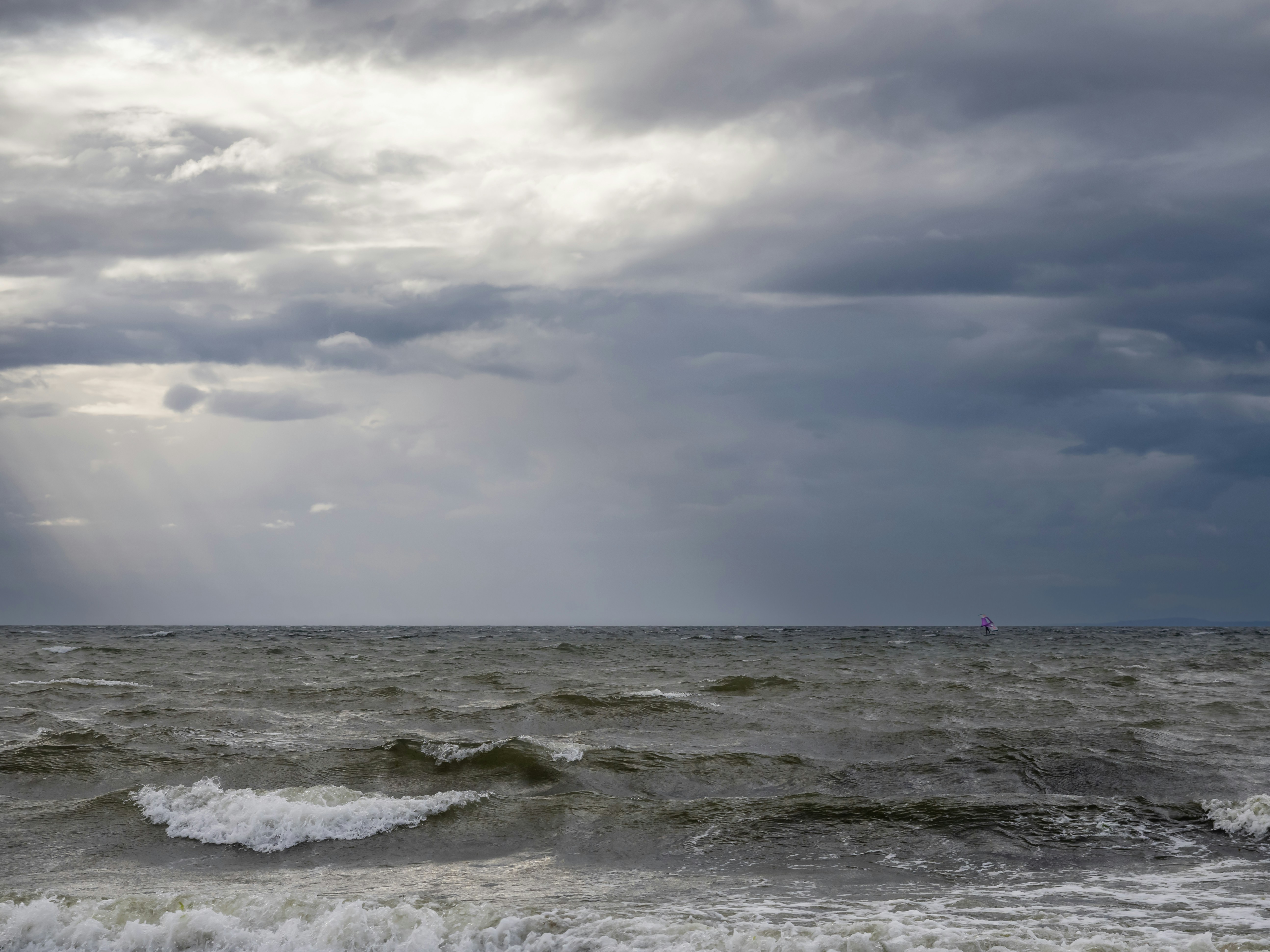 a large body of water under a cloudy sky
