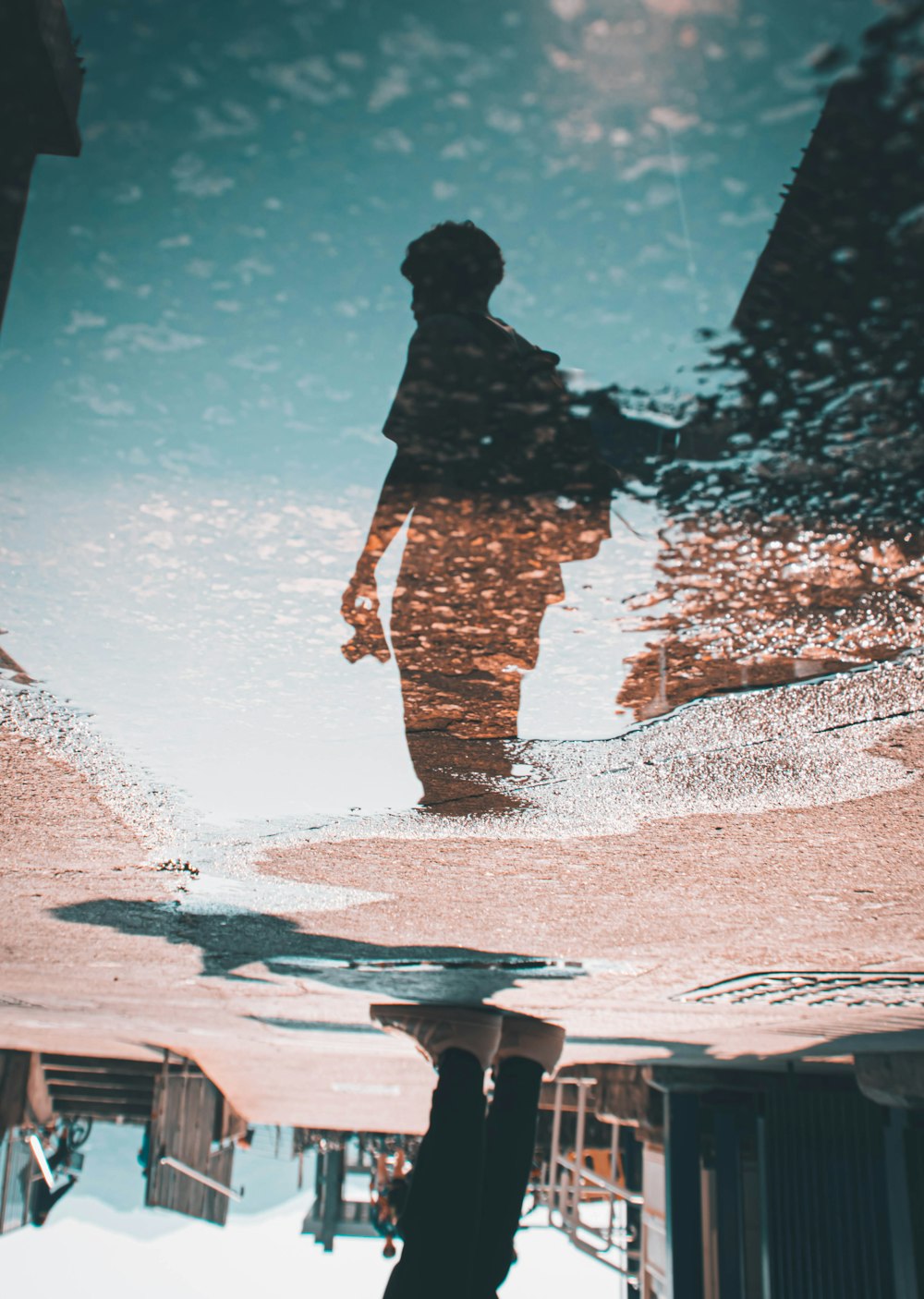 a reflection of a person in a puddle of water