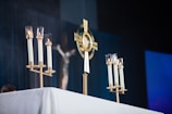 a table topped with candles and a cross on top of it