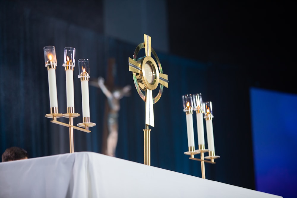 a table topped with candles and a cross on top of it