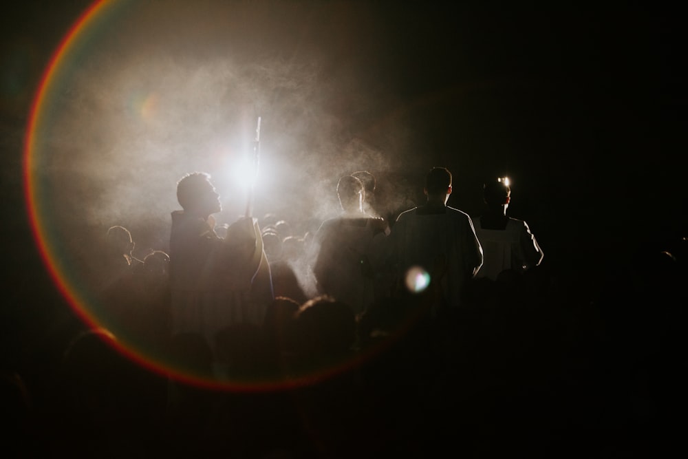 a group of people standing in the dark