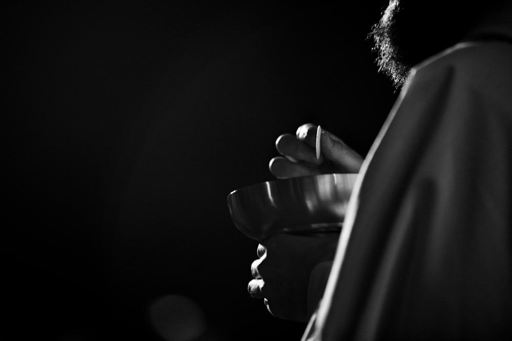 a black and white photo of a man holding a flower