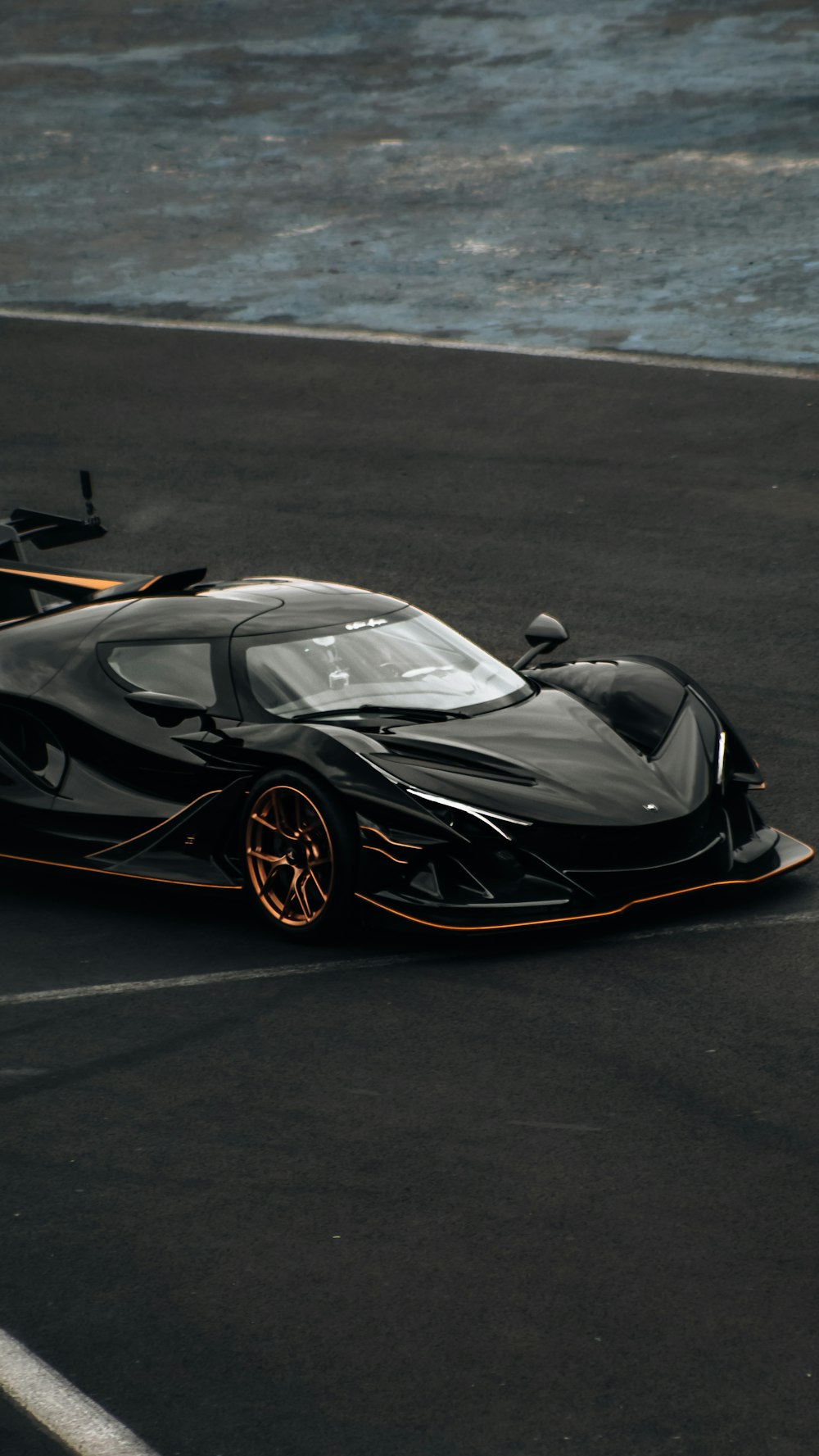 a black sports car driving on a race track