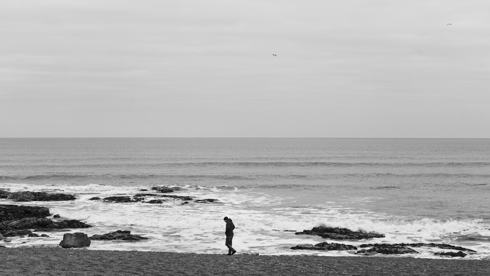 a person standing on a beach next to the ocean