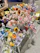 Close-up of a delicate handmade crochet flower bouquet in soft pastel colors resting on a wooden table.