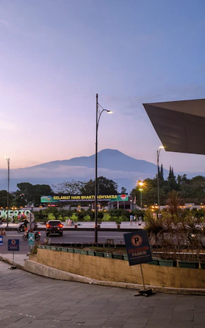 Night view of Batu city with illuminated streets and a modern car ready for a city tour.
