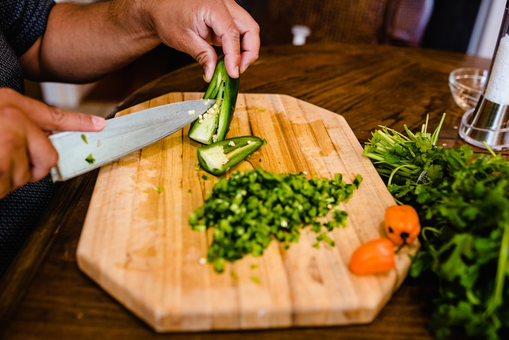 a person cutting vegetables on a cutting board