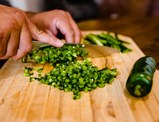 Hands carefully packing fresh produce in a clean, bright kitchen with natural light streaming in.