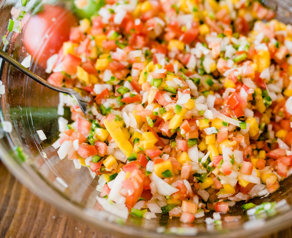 a glass bowl filled with chopped up vegetables