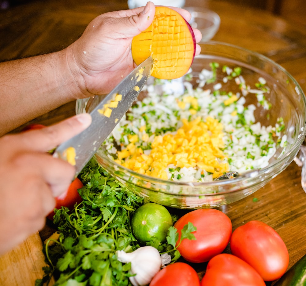 a person cutting up vegetables on a cutting board