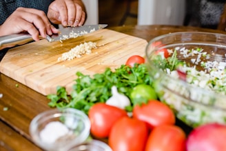 A busy home cook swiftly chopping vegetables at a kitchen counter, surrounded by fresh ingredients and a sizzling skillet.
