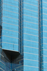 a plane flying in front of a very tall building