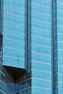 a plane flying in front of a very tall building
