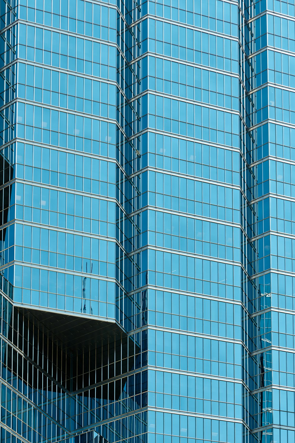 a plane flying in front of a very tall building