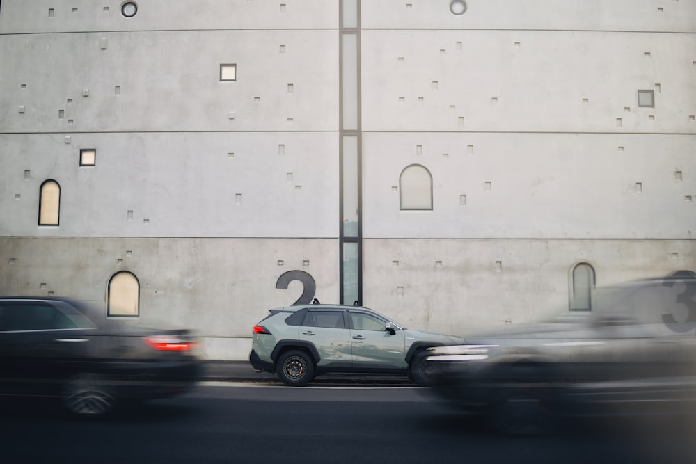 a car driving down a street next to a tall building