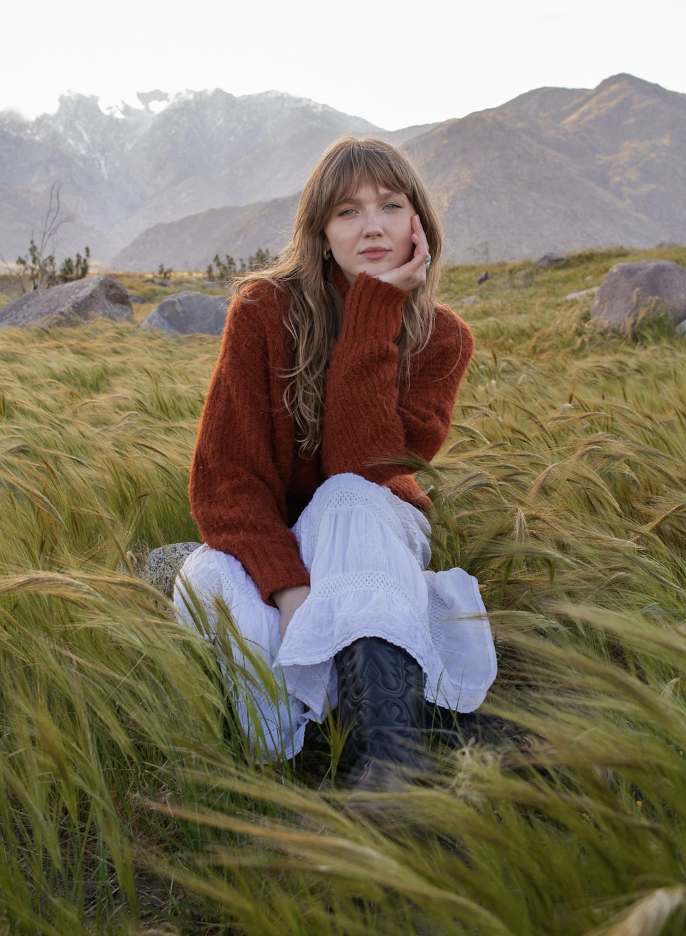 a woman sitting in a field of tall grass