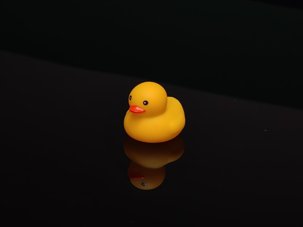 Un pato de goma amarillo sentado encima de una mesa