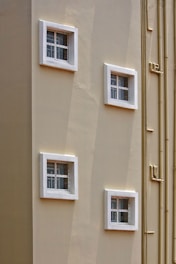 a building with four windows and bamboo poles