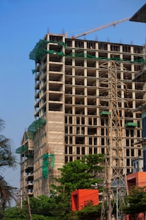 a tall building with a crane in front of it