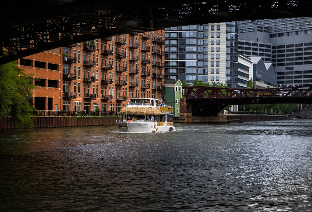 a boat traveling down a river next to tall buildings