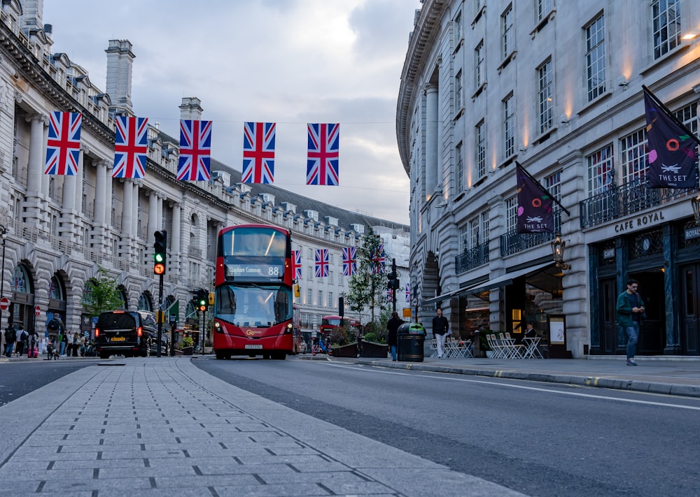 a red double decker bus driving down a street