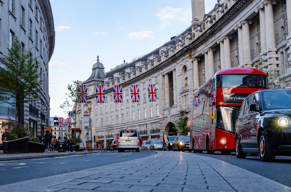 a red double decker bus driving down a street