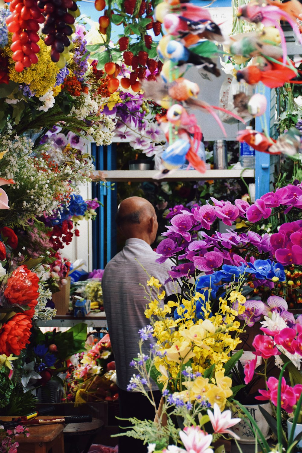 a man is looking at a bunch of flowers