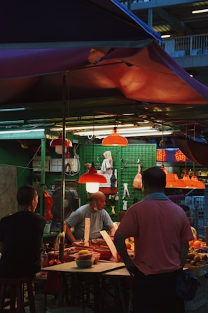 People gathered around a stall sharing stories and local produce.
