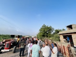 A group of people gathered outdoors in a rural community meeting.