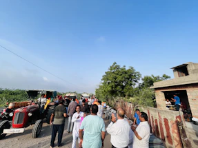 A warm community meeting in a rural setting discussing sustainable agriculture.
