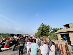 A group of people gathered outdoors in a rural community meeting.